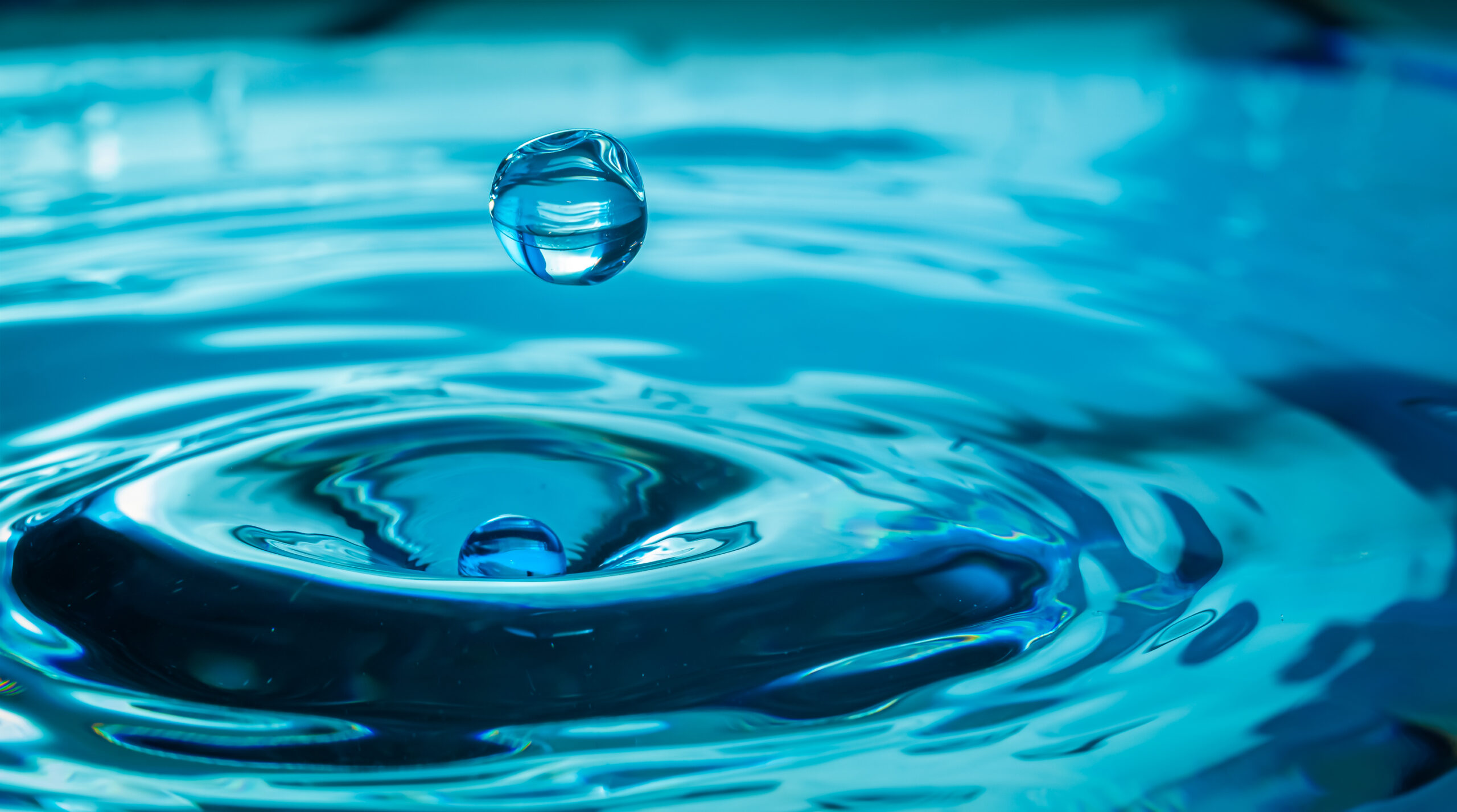 Wassertropfen fällt auf eine Wasseroberfläche